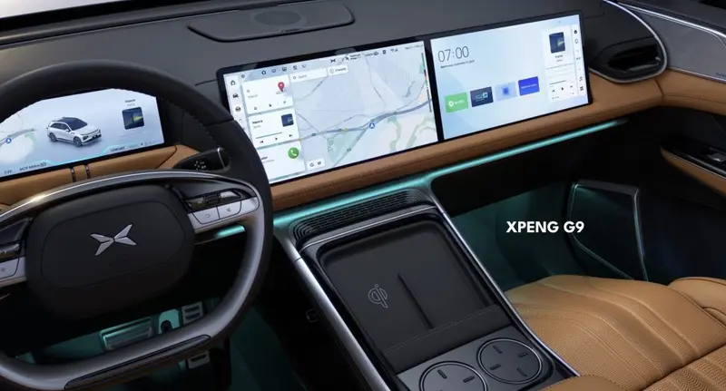 XPeng G9 interior with wide dashboard touchscreens, ambient lighting and tan leather seats