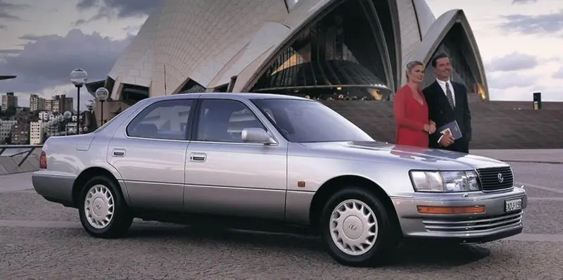 Silver 1990 Lexus sedan with a couple in evening wear outside the Sydney Opera House