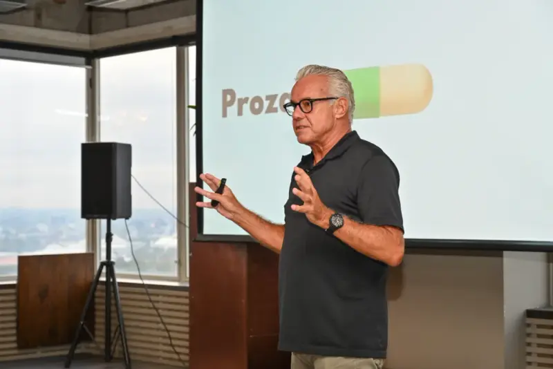 Richard presenting to pharma marketers in Melbourne, a Prozac slide on the screen behind him